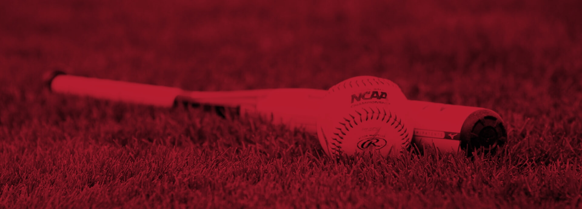 Red overlay on baseball and bat laying on grass